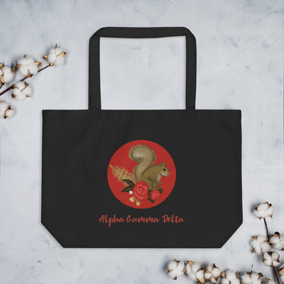 Alpha Gamma Delta Squirrel Large Organic Tote Bag in black shown flat with cotton blossoms