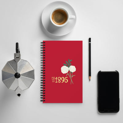 Chi Omega 1895 Founding Date Spiral Notebook shown with coffee