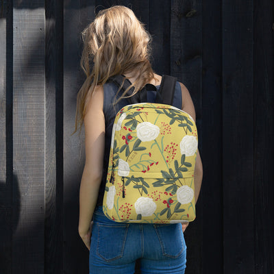 Chi Omega white carnation floral print backpack with straw background shown on model