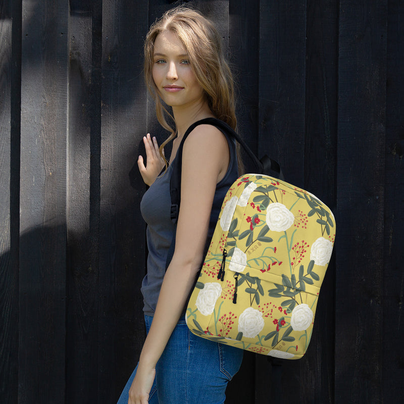 Chi Omega white carnation floral print backpack with straw background shown on model&