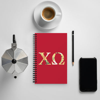 Chi Omega Greek Letters Spiral Notebook shown with coffee
