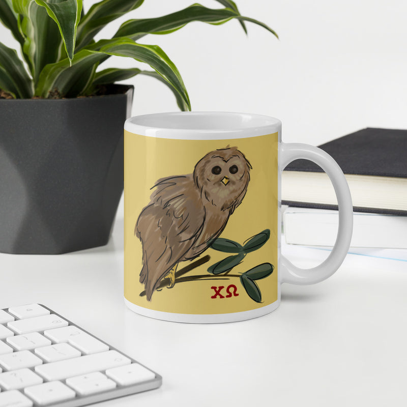 Front of Chi Omega 11 oz owl mug shown on desk..