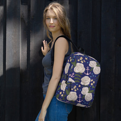 Delta Gamma white rose floral print backpack with a blue background shown on woman's shoulder