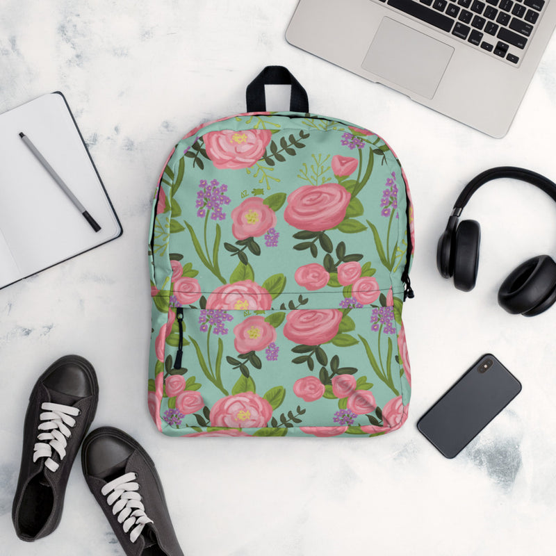 Delta Zeta pink rose floral print backpack with light green background shown in lifestyle setting