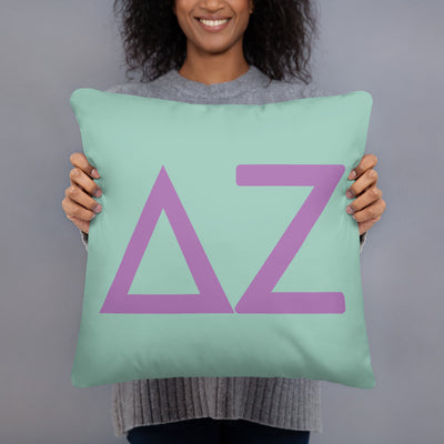 Delta Zeta Green Greek Letters Pillow in model's hands