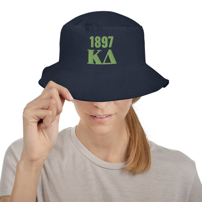 Kappa Delta 1897 Founding Date Bucket Hat in Navy with green embroidery on model's head