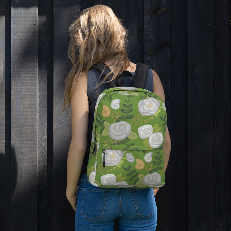 Kappa Delta white rose print backpack with a green background shown on model