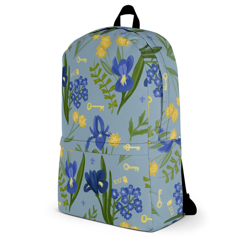 Kappa Kappa gamma iris print backpack with a blue background showing left side view.