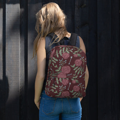 Pi Beta Phi wine carnation print backpack with arrows and a wine background shown on model's back