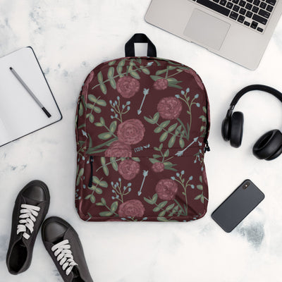 Pi Beta Phi wine carnation print backpack with arrows and a wine background shown in office