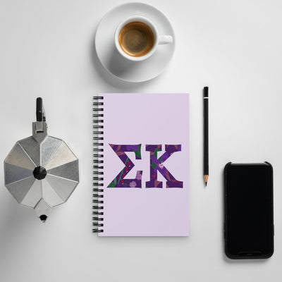 Sigma Kappa Filled Letters Spiral Notebook shown with coffee in lifestyle setting