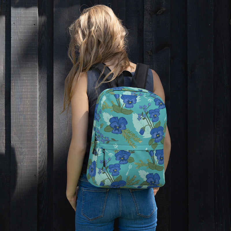 Pansy Floral print backpack with a teal background shown on model
