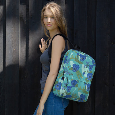 Front view of the Tri Delta Pansy Floral print backpack shown on woman's shoulder. 
