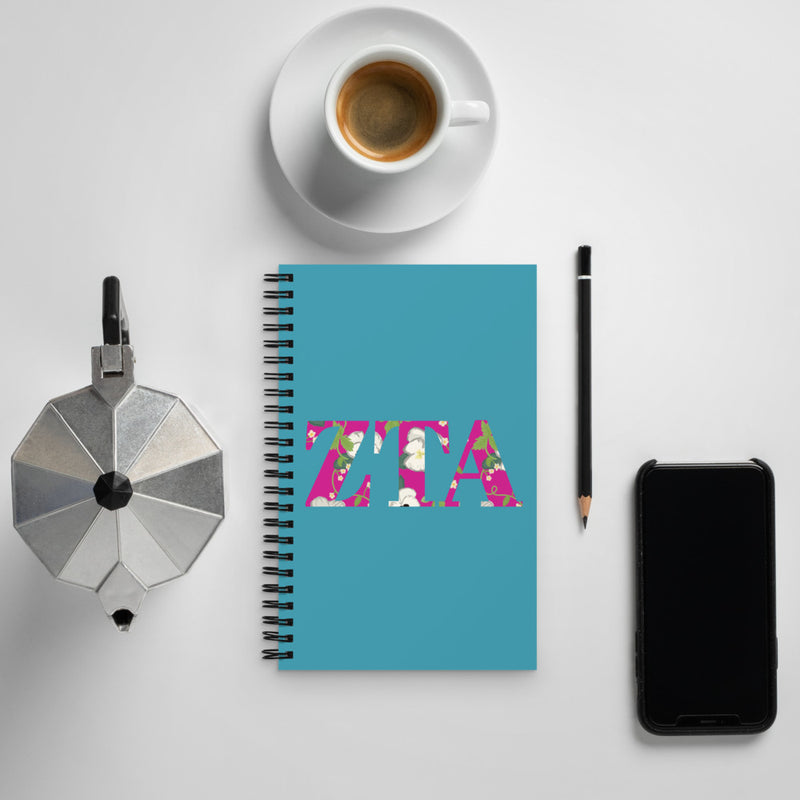 Zeta Tau Alpha Greek Letters Spiral Notebook, Turquoise shown with coffee
