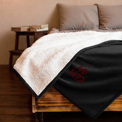 Alpha Phi Plush Embroidered Sherpa Blanket in black on bed