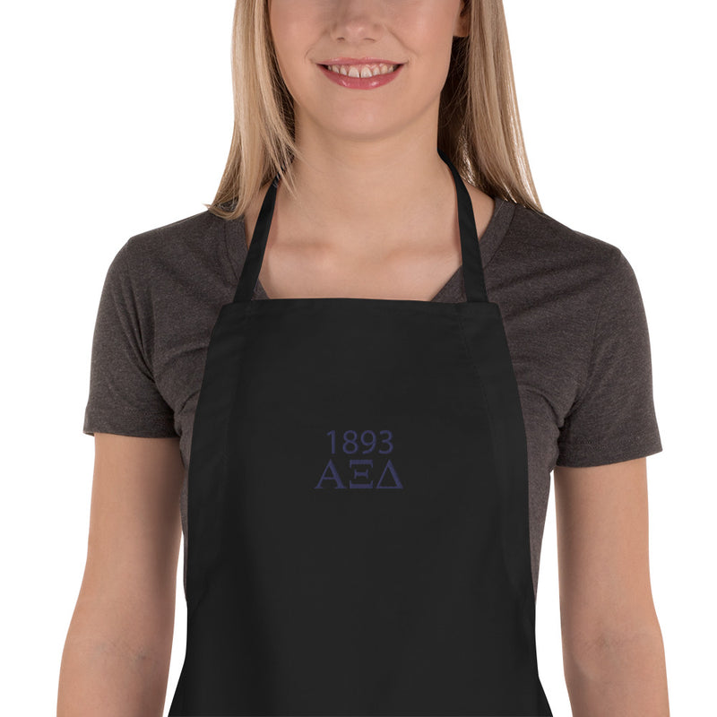 Alpha Xi Delta Embroidered Apron in close up view in black with Navy lettering on front