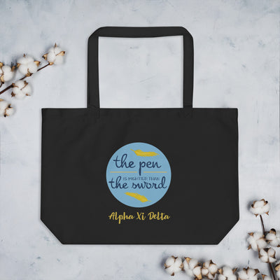 Alpha Xi Delta Pen Is Mightier Tote Bag in black shown with cotton blossoms