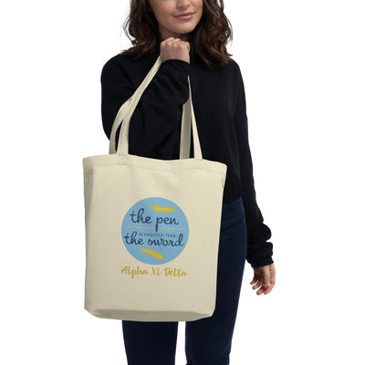 Alpha Xi Delta Pen is Mightier Eco Tote Bag shown in natural oyster on model's arm
