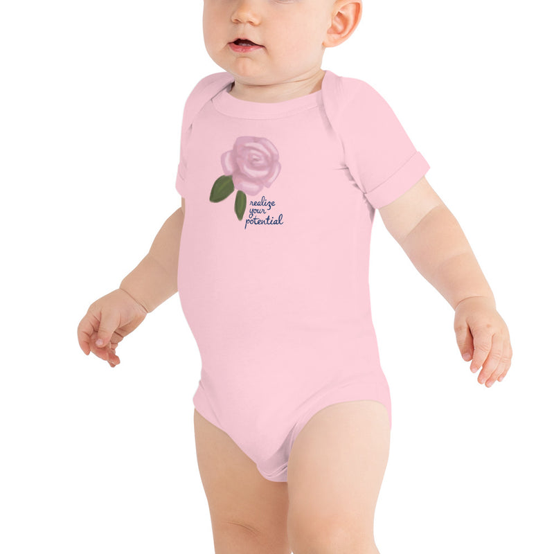 Alpha Xi Delta Realize Your Potential Baby Onesie in pink on an infant