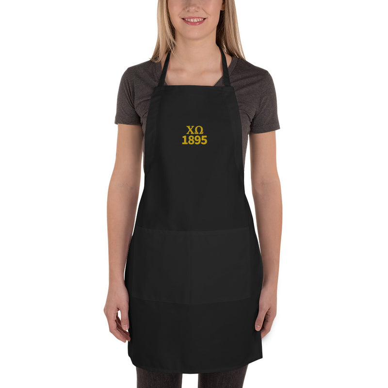 Chi Omega Embroidered Apron in black with gold embroidery shown on model in full length view