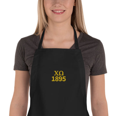 Chi Omega Embroidered Apron in black with gold embroidery shown on model 