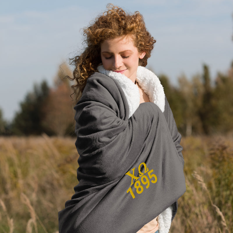 Chi Omega Plush Sorority Blanket in gray with gold embroidery shown with model