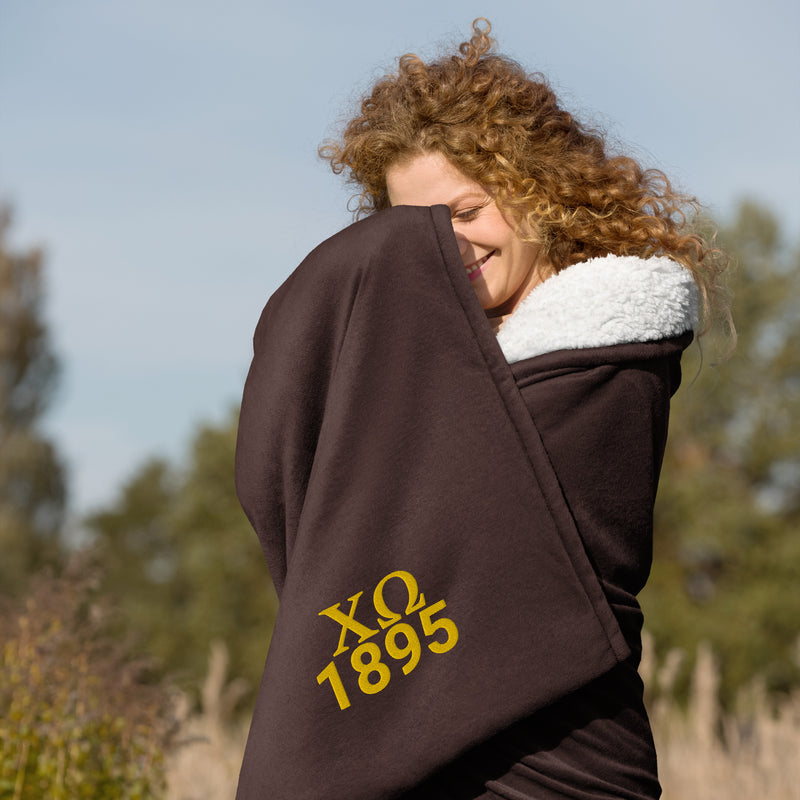Chi Omega Plush Embroidered Sherpa Blanket in brown on model