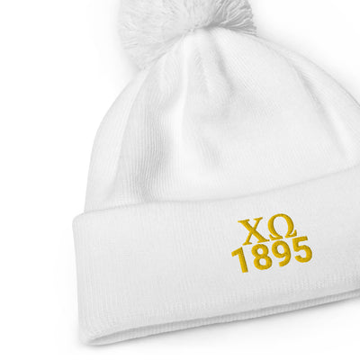 Chi Omega Pom Pom Beanie in white with gold embroidery in close up view