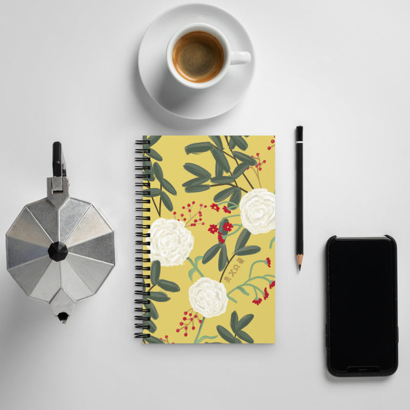 Chi Omega Sorority Notebook shown with in lifestyle setting with floral print cover