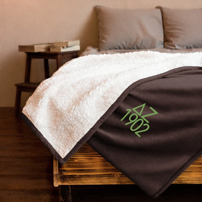 Delta Zeta Plush Embroidered Sherpa Blanket in brown on bed