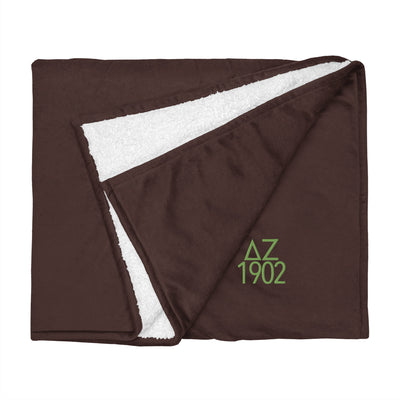 Delta Zeta Sorority Sherpa Blanket in brown with green embroidery shown flat