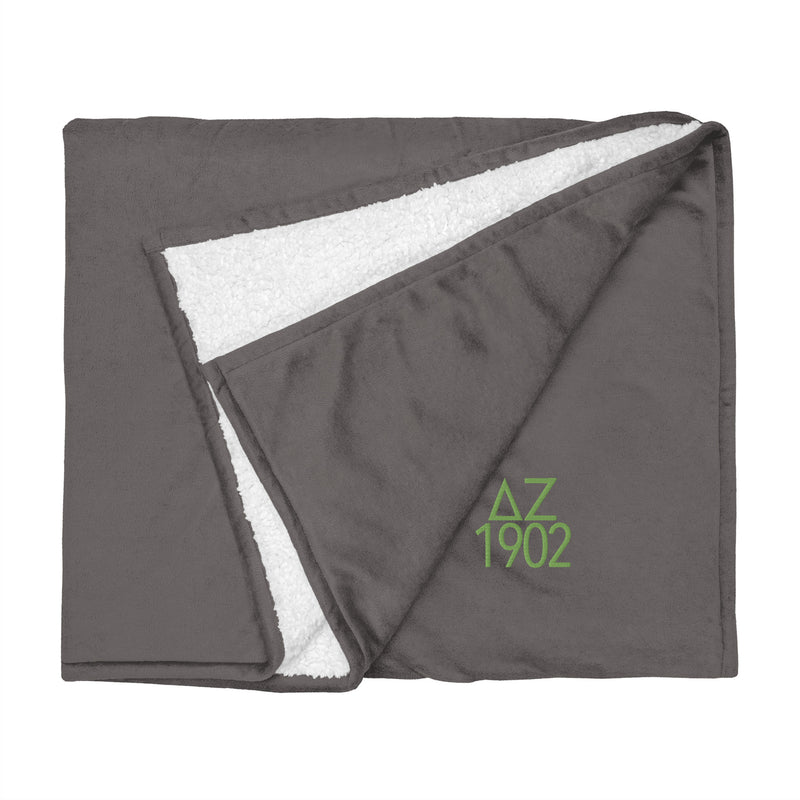 Delta Zeta Sorority Sherpa Blanket in gray with green embroidery shown flat