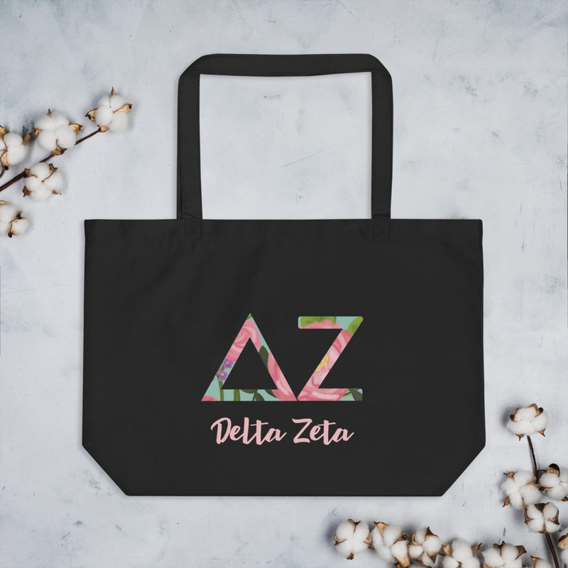 Delta Zeta Sorority Tote Bag in black shown flat with cotton blossoms