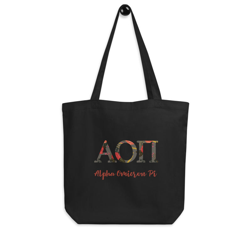 Alpha Omicron Pi Greek Letters Eco Tote Bag in black shown on a hook