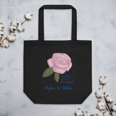 Alpha Xi Delta Realize Your Potential Eco Tote Bag shown in black with cotton blossoms