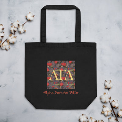 Alpha Gamma Delta Greek Letters Eco Tote Bag in black shown with coton blossoms