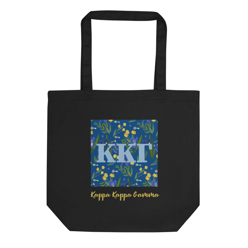 Kappa Kappa Gamma Greek Letters with a blue iris pattern behind. Printed on a black canvas shopping tote.