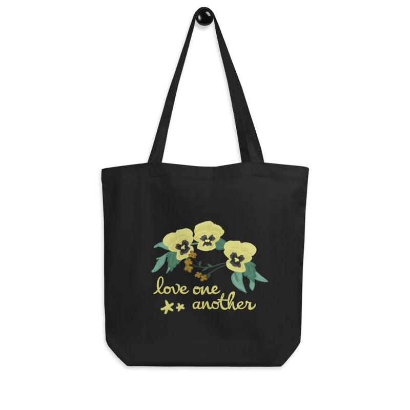Kappa Alpha Theta Love One Another Eco Tote Bag in black on a hook