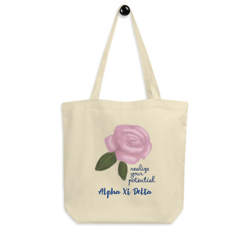Alpha Xi Delta Realize Your Potential Eco Tote Bag shown on a hook