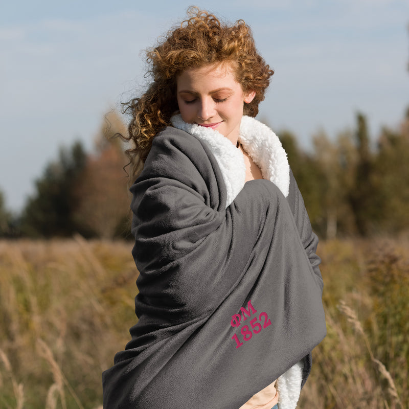 Phi Mu 1852 Embroidered Sherpa Blanket in gray wrapped around woman