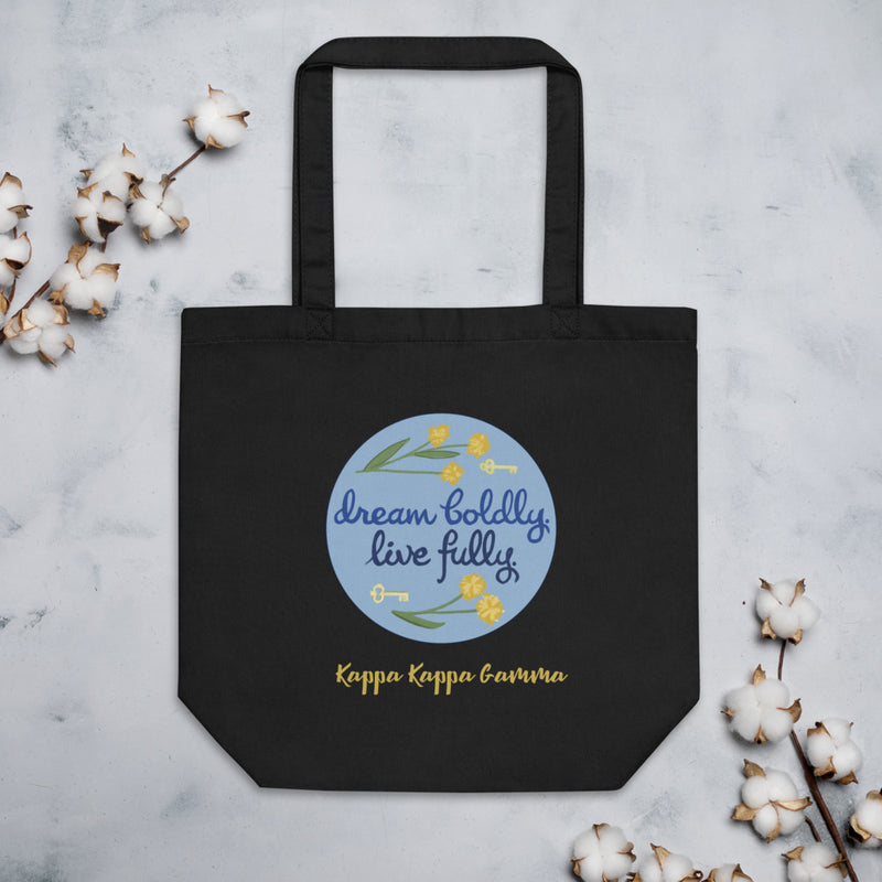 Kappa Kappa Gamma Dream Boldly. Live Fully. motto printed on a black canvas bag shown with cotton blossoms