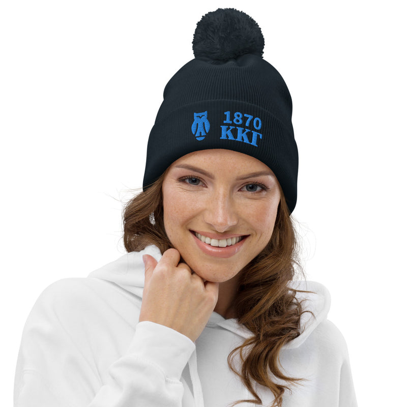 Kappa Kappa Gamma 1870 Pom Pom Beanie in Navy blue embroidered with founding year, letters and owl symbol shown on model&