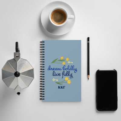 Kappa Kappa Gamma Sorority Motto Dream Boldly. Live Fully Spiral Notebook shown in lifestyle setting with coffee