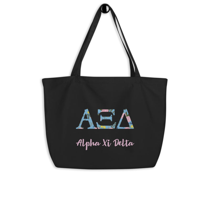 Alpha Xi Delta Greek Letters Large Organic Tote Bag in black shown on a hook