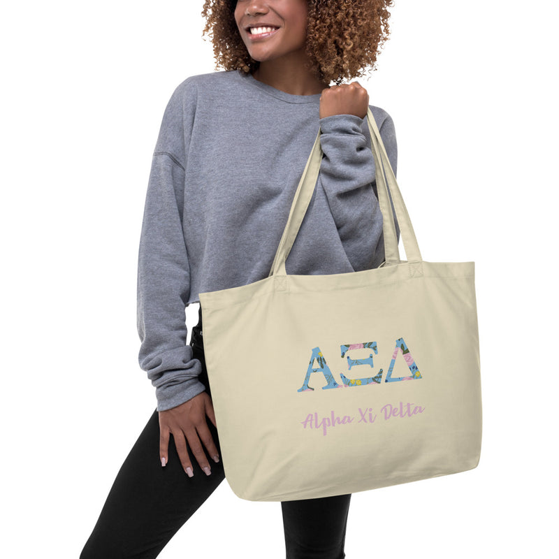 Alpha Xi Delta Greek Letters Large Organic Tote Bag shown in natural oyster color on model&