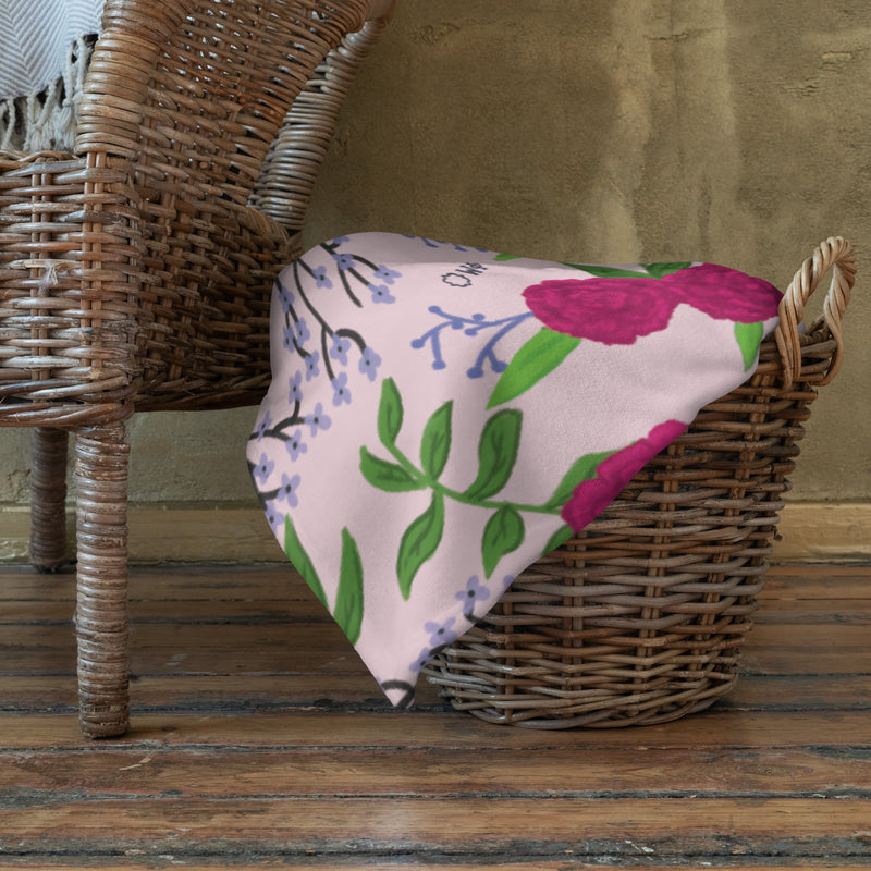 Phi Mu Pink Carnation Floral Print Throw Blanket shown in basket