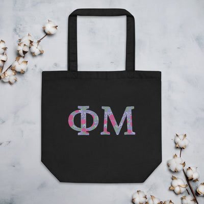 Phi Mu Filled Letters Eco Tote Bag in black shown flat with cotton blossoms