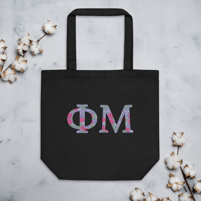 Phi Mu Filled Letters Eco Tote Bag in black shown flat with cotton blossoms