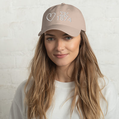 Sigma Kappa embroidered baseball hat in stone with white embroidery shown on model's head