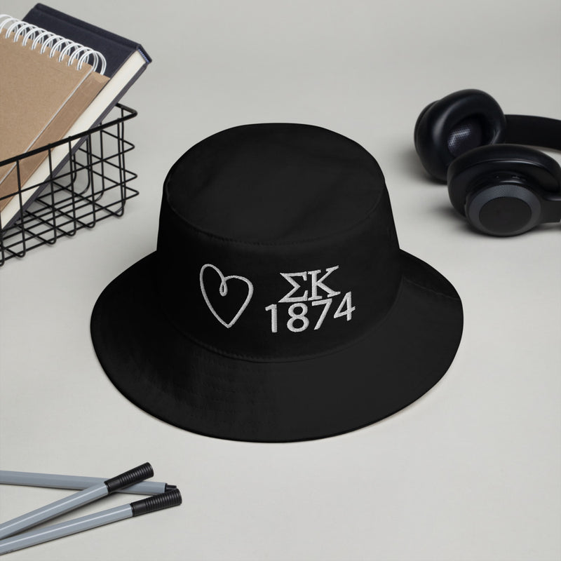 Sigma Kappa Heart Embroidered Bucket Hat in black with white embroidery shown in lifestyle setting